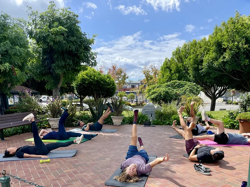 Outdoor yoga session in a sunny garden courtyard