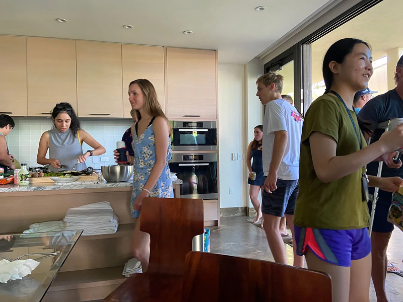 Digital foundry software engineers and consultants mingle while preparing food in the kitchen of a resort villa in hawaii